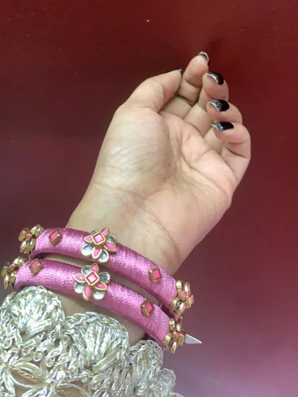 A collection of my pink silk thread bangles, showcasing a variety of designs from simple geometric patterns to elaborate floral kundan work.