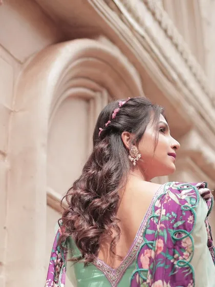 The back view of the turquoise blue lehenga with its modern peplum blouse and beautifully printed cut-work dupatta.