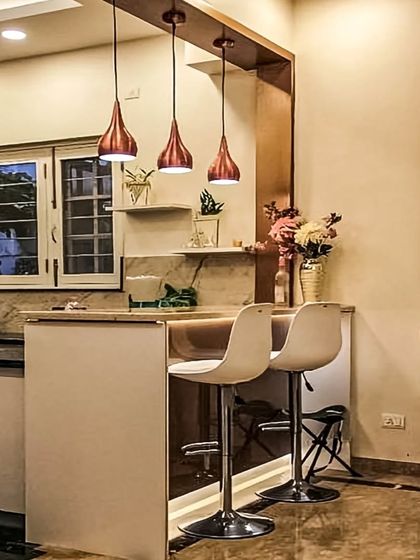 This design shows how a simple breakfast counter can connect the kitchen to the living area. It's a perfect spot for quick meals, complemented by stylish pendant lights that define the space.