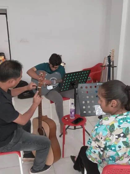 A guitar class in session. We have guitars available for students to use at the center.