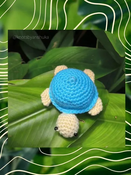 A tiny blue crochet turtle, perfect for hanging on your bag or keys. The shell texture is created with careful stitching.