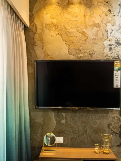 A detail shot of the TV mounted on the natural stone veneer wall. The warm, earthy tones of the stone create a beautiful contrast with the sleek screen.
