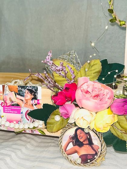 A close up of the floral arrangement and personalized photo frame on a Taylor Swift themed hamper, blending fandom with beautiful aesthetics.
