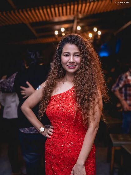 A guest in a sparkling red dress, shining on the dance floor.