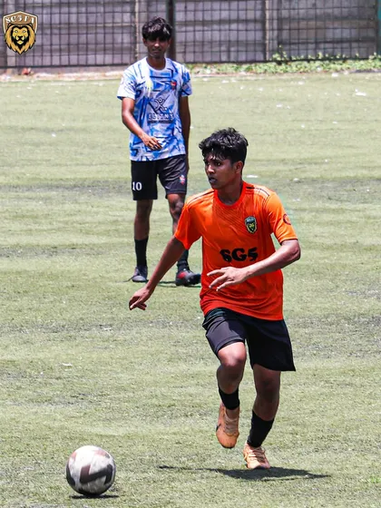 An SG5 player on the attack, running with the ball during an MFA First Division game.