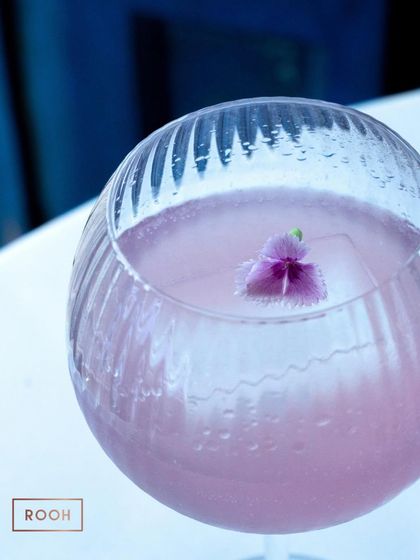 A close-up of the Lavender Magic, where you can see the single edible flower suspended in the large ice cube. It's artistry in a glass.