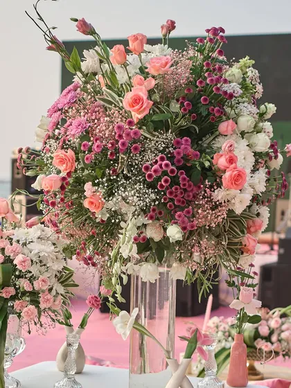 A lush, oversized floral arrangement in a tall glass vase, used as a statement piece. I combined various shades of pink and white flowers to add texture and depth to the decor.