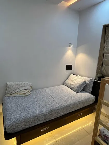 A single bed with built-in storage drawers underneath, perfect for a kid's room or guest room. The under-bed lighting adds a warm, ambient glow to the space.