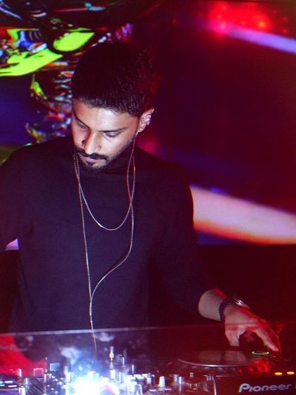A close-up of me working the Pioneer DJ controller. The colorful, abstract visuals on the screen behind me add to the atmosphere of this intimate club setting.