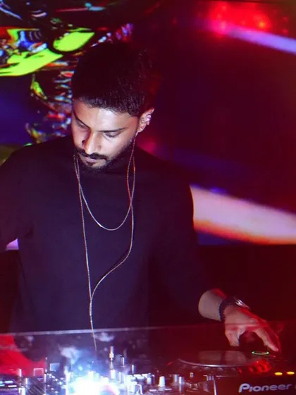 A close-up of me working the Pioneer DJ controller. The colorful, abstract visuals on the screen behind me add to the atmosphere of this intimate club setting.