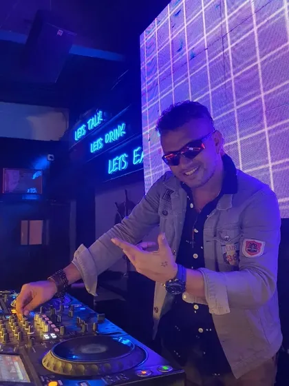 All smiles behind the console, pointing to the crowd. My focus is always on the people, making sure everyone is having a great time.