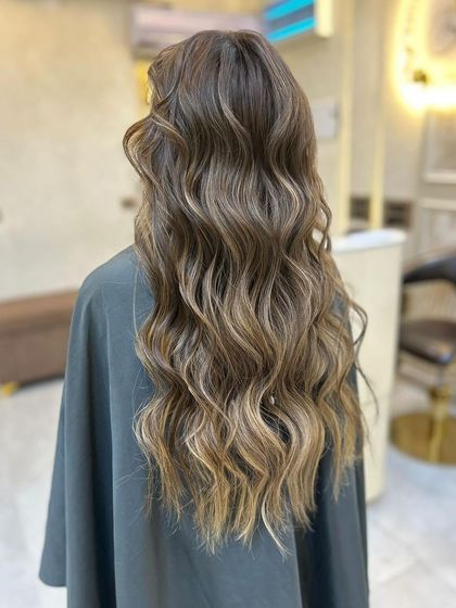 The light catching the waves of this olive ashy brown balayage, showing off the beautiful, multi-dimensional colour.