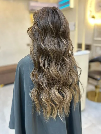 The light catching the waves of this olive ashy brown balayage, showing off the beautiful, multi-dimensional colour.