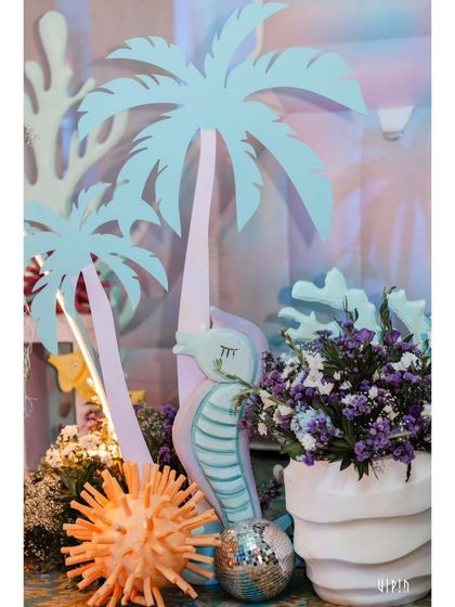 A close-up of the decor, featuring a seahorse prop, a disco ball for sparkle, and floral arrangements. The combination of different textures and themes adds depth and interest.