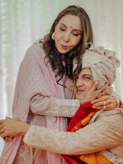 A mother's tender embrace for her son, the groom, on his wedding day. A quiet, powerful moment.