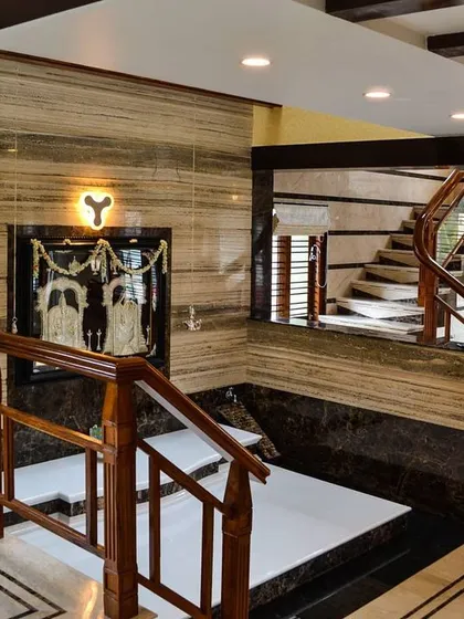 My interior design work focuses on creating elegant and functional spaces. This view of a staircase and foyer in a Rajajinagar residence highlights the use of rich wood for the railings, polished marble cladding, and integrated lighting to create a warm, luxurious feel.