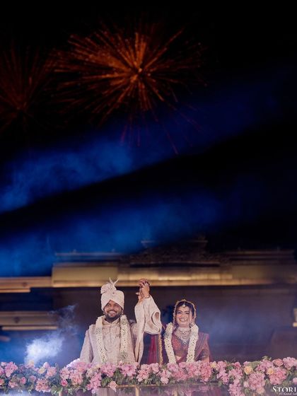 The couple celebrating with fireworks in the background, a perfect end to their wedding night.