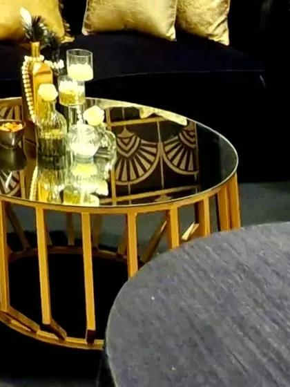 A detail shot of the lounge area, where the gold table, plush velvet sofa, and themed decor accessories come together to create a luxurious and cohesive black and gold aesthetic.