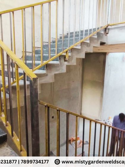 A wider view of the multi-level metal staircase at the farmhouse. The continuous railing provides safety across the different flights of stairs, all fabricated with consistent quality and design.