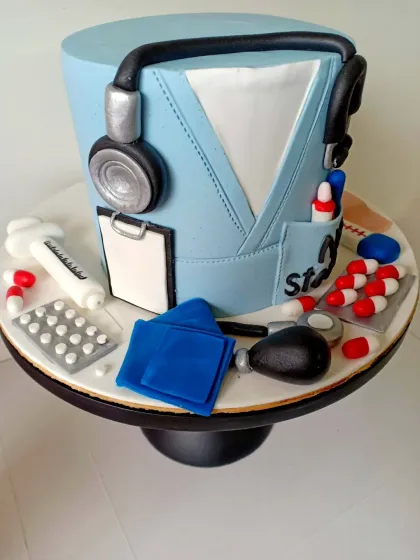 A side view of the doctor scrub cake, highlighting the edible stethoscope, syringe, and blood pressure cuff. It’s a 360-degree celebration of the medical profession.