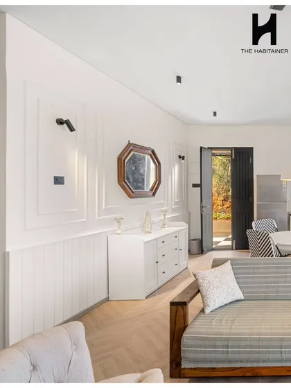 The living room of the French villa, showing the elegant wall paneling and a mix of modern and classic furniture.