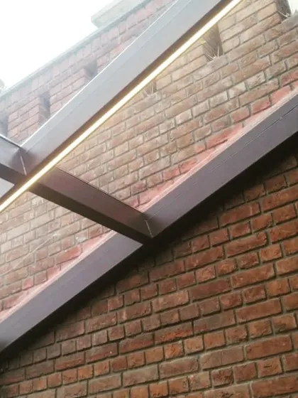 A close-up detail of the steel frame with integrated LED strip lighting. This feature provides subtle, modern illumination for the space in the evenings without the need for bulky fixtures.