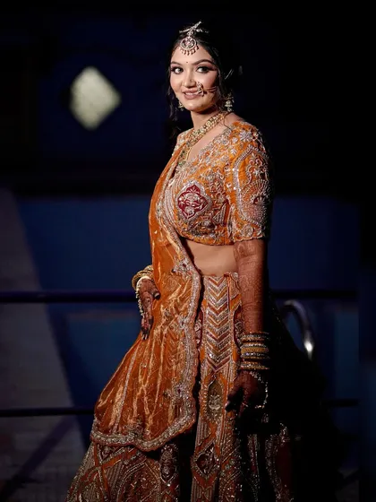 A full-length shot of the bride, showcasing the unique color and design of her lehenga.