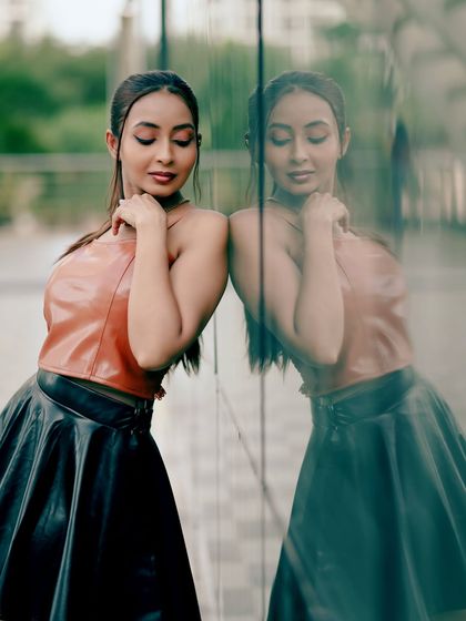 A contemplative pose, with the model's reflection adding depth and a sense of introspection.