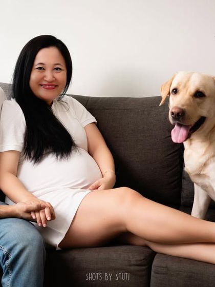 A full family portrait, including the furry family member. This shot captures the happy, complete family unit, eagerly awaiting their newest addition.