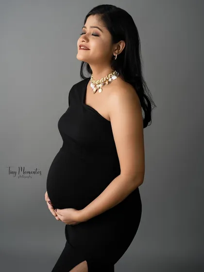 A profile shot that captures a moment of pure bliss. The simple black dress and pearl necklace add a touch of classic elegance.