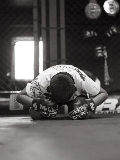 A young fighter bows his head in a moment of respect, a core value of our martial arts training.