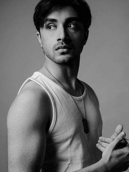 A simple and classic men's look featuring a white tank top and dog tag necklace. This timeless style is effective for headshots and portfolio images.