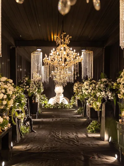 I believe in creating unique atmospheres, like this modern and dramatic Sangeet decor. The high-contrast theme with black draping, crystal chandeliers, and contemporary art installations offers a sophisticated and luxurious alternative to traditional setups, perfect for a chic evening celebration.