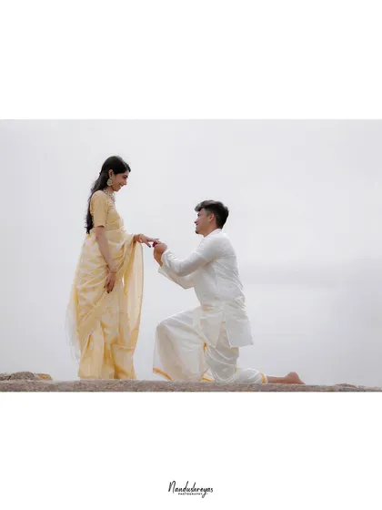 A minimalist, wide-angle shot of a proposal, creating a sense of space and focus on the couple.