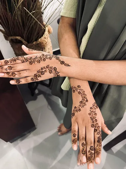 A delicate floral vine gracefully trails across the hands. This minimalist style is elegant and timeless, perfect for any occasion from Eid to a friend's wedding.