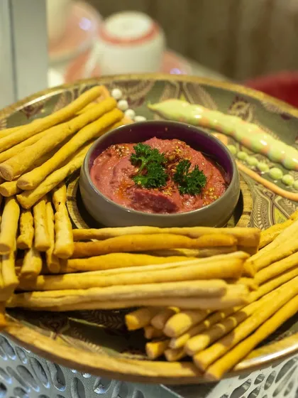 Crispy breadsticks served with a vibrant beetroot hummus. This simple yet delicious combination is a perfect snack or starter for any event.