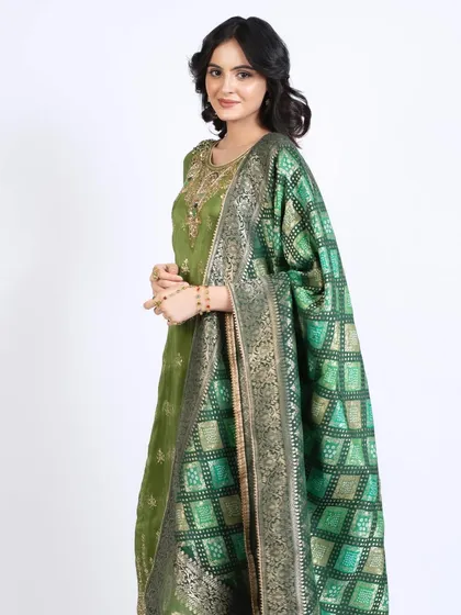 The full ethnic look, showing how the hair and makeup complement the rich green and gold attire.