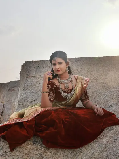 A full-length view of the model posed on the rocks. The bright, overcast sky acts like a giant softbox, providing even lighting that is flattering for portraits.