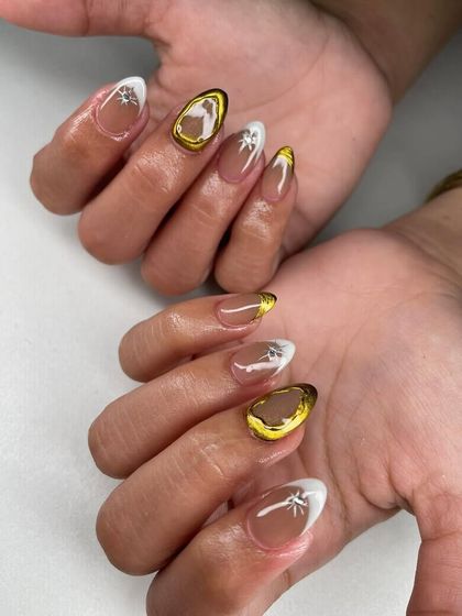 A modern design with white tips, gold chrome frames, and starburst accents. This is a chic and celestial-inspired look.