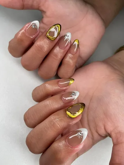 A modern design with white tips, gold chrome frames, and starburst accents. This is a chic and celestial-inspired look.