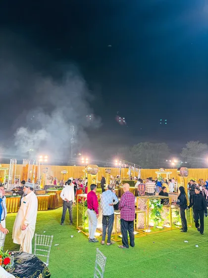 Guests mingling and enjoying the food at the various live counters, showcasing a lively event atmosphere.