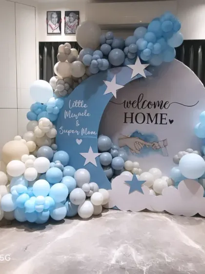 A wider view of the "Little Miracle & Super Mom" welcome home setup. This shows how the full arrangement, including the heart-shaped photo collage, comes together to fill the space with love.