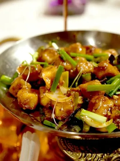 A serving of our Tangra-style chili chicken, a classic Indo-Chinese dish that is a staple on our menu. It's prepared with the authentic flavors of Kolkata's Chinatown and served in traditional metalware.