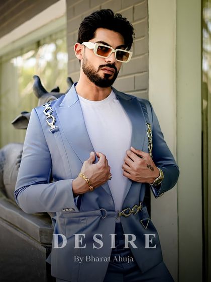 A closer view of the light blue blazer, highlighting the unique chain-link hardware and the smooth, satin-like texture of the fabric.