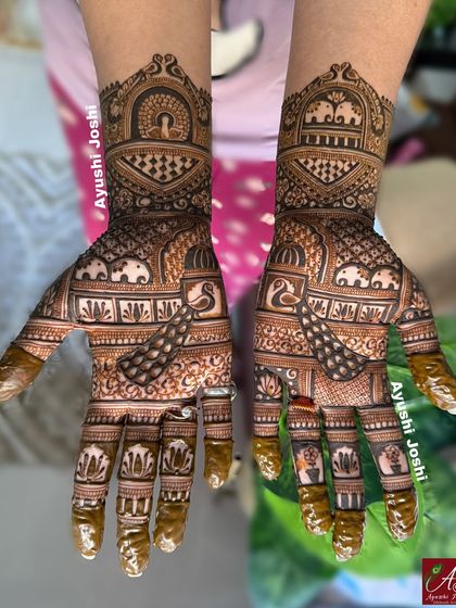 The full two-hand view of the royal Karva Chauth mehendi, with the henna paste still on, ready for a dark stain.