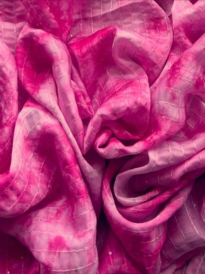 The intense fuchsia of this tie-dye tabby silk is absolutely breathtaking. It's a fabric that's made for celebration, perfect for a vibrant lehenga or saree.