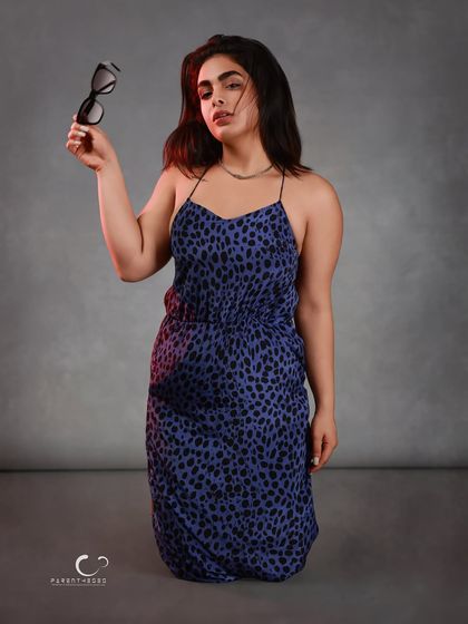 The moment the mask comes off. Holding the sunglasses as a prop, her direct gaze connects with the viewer, revealing the personality behind the stylish facade.