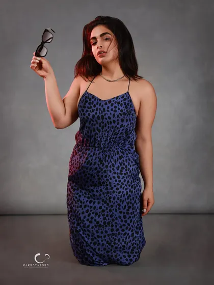 The moment the mask comes off. Holding the sunglasses as a prop, her direct gaze connects with the viewer, revealing the personality behind the stylish facade.
