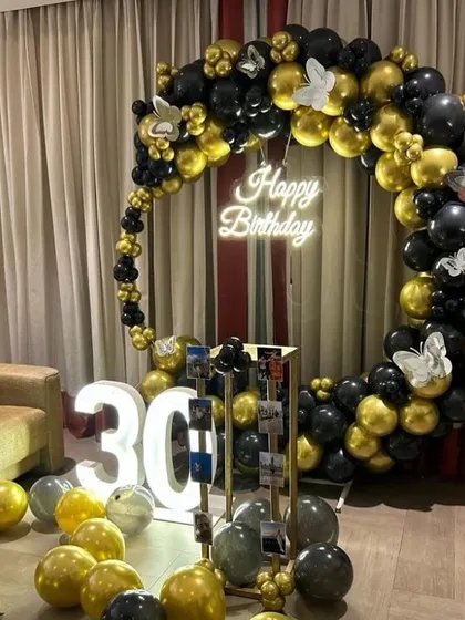 Celebrate a milestone 30th birthday in style with this chic black and gold theme. The decoration includes a full balloon ring, large light-up numbers, and a photo display stand, creating a sophisticated and fun party atmosphere.