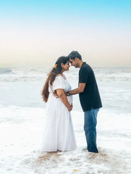 A quiet, intimate moment for expecting parents on a serene Mumbai beach. The soft light and gentle waves create a timeless and romantic portrait that focuses entirely on their connection before the baby arrives.